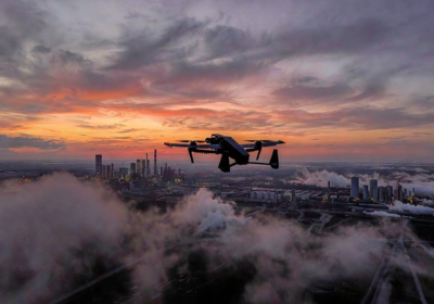 Ukrainian long-range drone flying over industrial skyline at dusk during Russia Ukraine war 2026