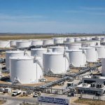 Conceptual image illustrating a G7 Oil Release, showing large industrial oil storage tanks under a clear blue sky
